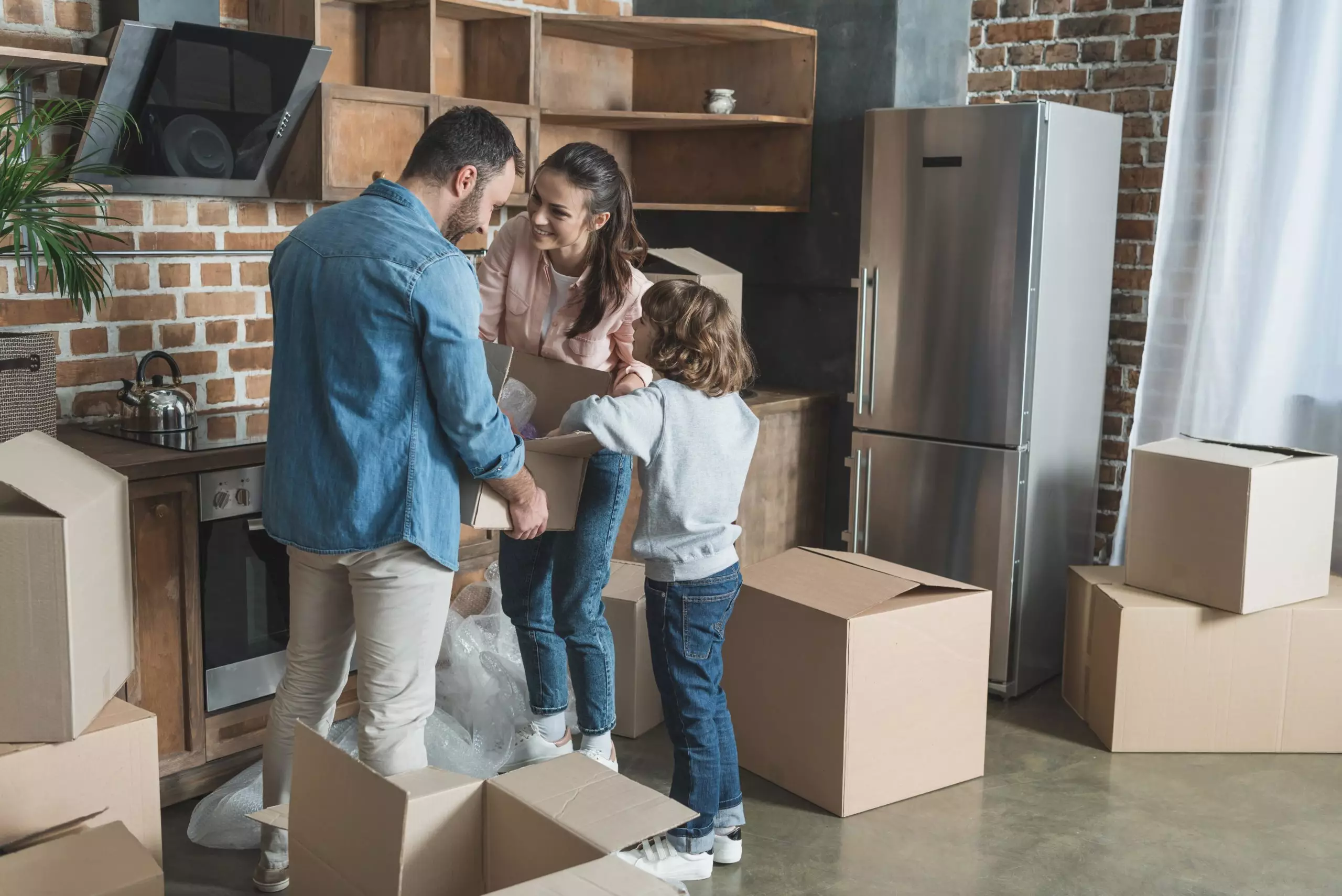 Happy Family Packing Cardboard Boxes While Moving