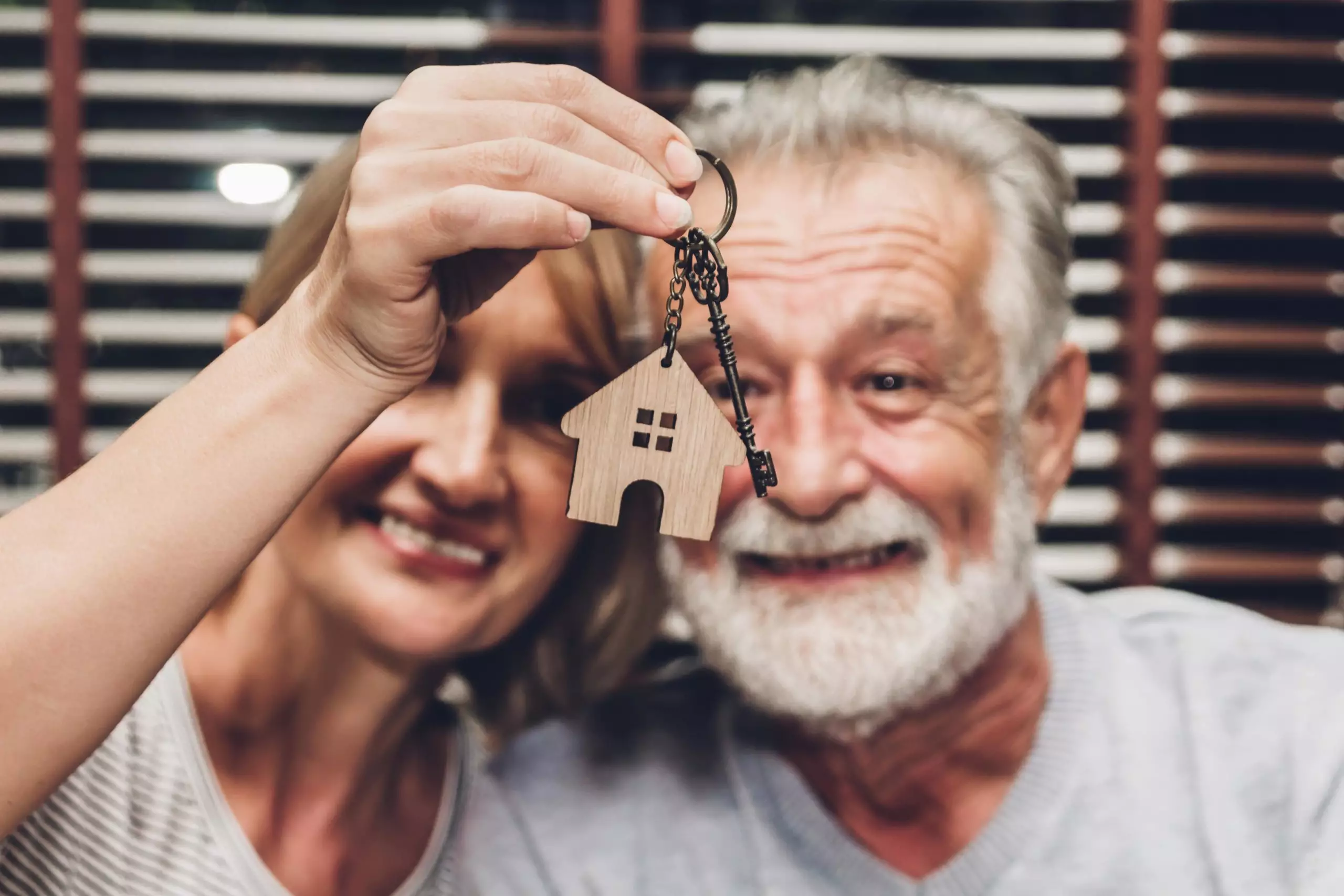 Elderly couple smiling with house key